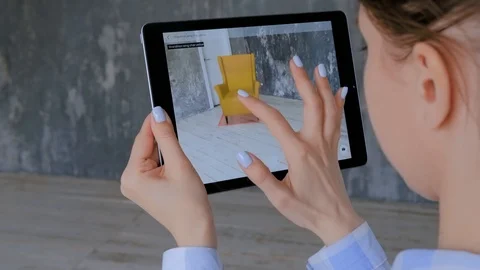 Woman using tablet with augmented reality app and placing 3d furniture in room Stock Footage 121646155