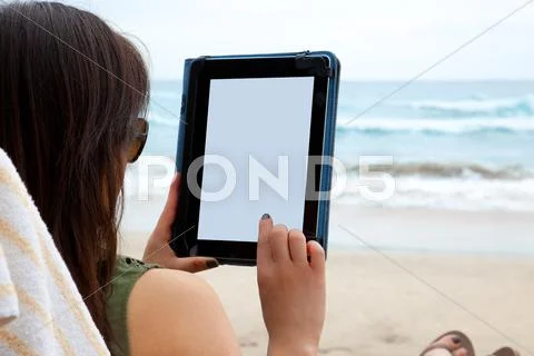 Woman using tablet on beach Stock Photos