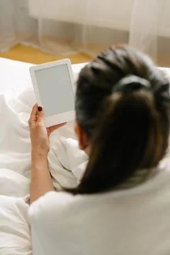 Woman using tablet on bed during weekend Stock Photos
