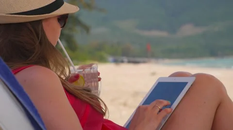 Woman using tablet computer on the beach Stock Footage 63598029