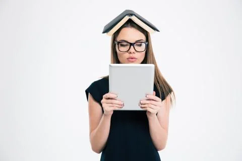 Woman using tablet computer with book on head Foto stock