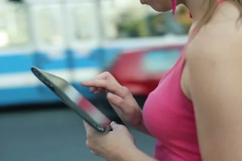 Woman using tablet computer in the city, steadicam shot NTSC Stock Footage 12133528