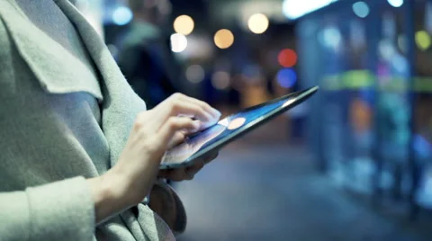 Woman using tablet computer in city at night Stock Footage 64455568