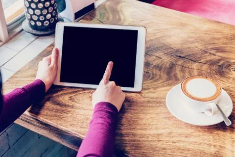 Woman using tablet computer in coffee shop with vintage tone. Stock Photos