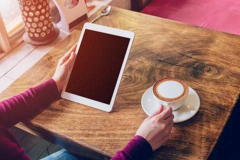 Woman using tablet computer in coffee shop with vintage tone. Stock Photos
