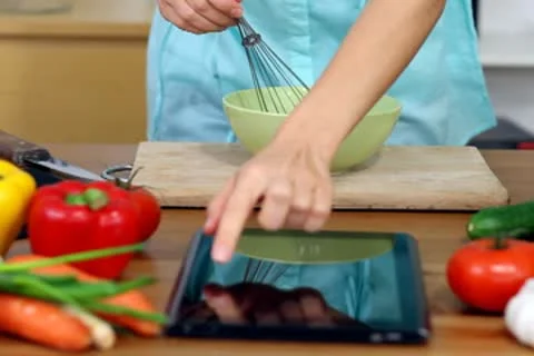 Woman using a tablet computer to cook in her kitchen Stock Footage 8983814