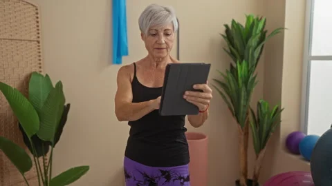 Woman using tablet computer in gym with plants and exercise equipment in th.. Stock Footage 292114656