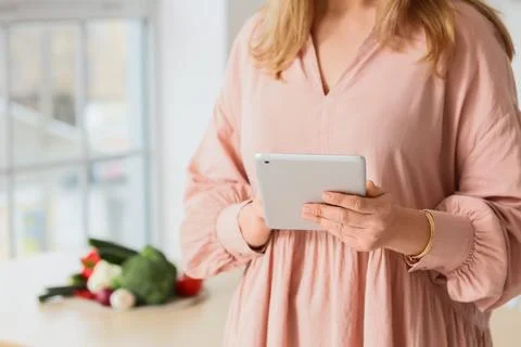 Woman using tablet computer in kitchen, closeup Stock Photos