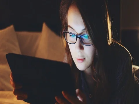 Woman using Tablet Computer at night, wearing glasses. SLOW MOTION 4K DCi 動画素材 75666429