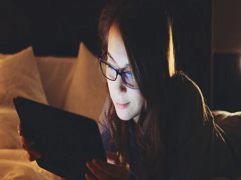 Woman using Tablet Computer at night, wearing glasses. SLOW MOTION 4K DCi Vídeos de archivo 75667736