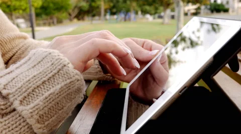 Woman using Tablet Computer Outdoors in a Park Stock Footage 62934927