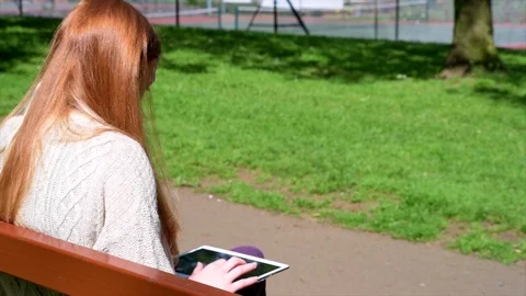 Woman Using Tablet Computer In Park Stock Footage 90737412