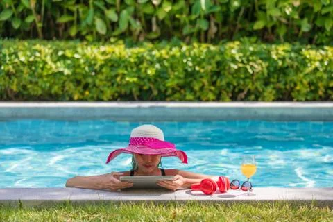 Woman using tablet computer in pool Stock Photos