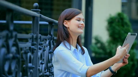 Woman using a tablet computer with a touch screen writes a message to a friend. Stock Footage 68905850