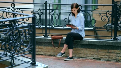 Woman using a tablet computer with a touch screen writes a message to a friend. Stock Footage 68905971