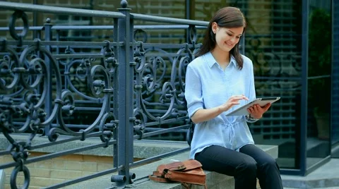 Woman using a tablet computer with a touch screen writes a message to a friend. Stock Footage 68906789