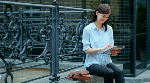 Woman using a tablet computer with a touch screen writes a message to a friend. Stock Footage 68907043