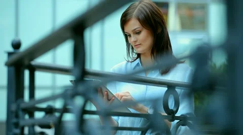 Woman using a tablet computer with a touch screen writes a message to a friend. Stock Footage 68907128