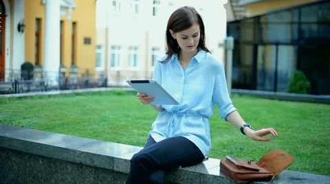 Woman using a tablet computer with a touch screen writes a message to a friend. Stock Footage 68907633