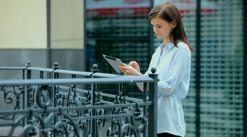 Woman using a tablet computer with a touch screen writes a message to a friend. Stock Footage 68907749