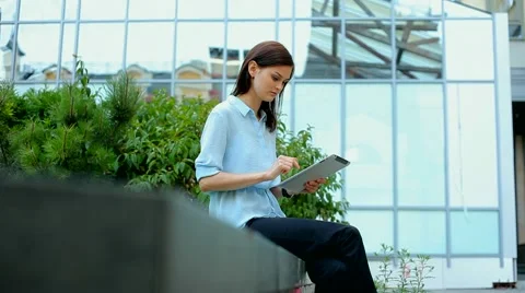 Woman using a tablet computer with a touch screen writes a message to a friend. Stock Footage 68907991