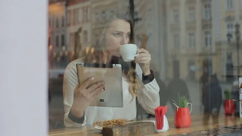 Woman using tablet computer touchscreen in cafe drinking coffee Stock Footage 72341078