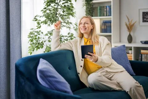 Woman using tablet on couch Stock Photos