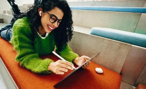 Woman using tablet for creative work in public library with stylus and head.. Stock Photos