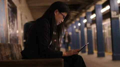 Woman using Tablet on Dark Subway Platform Vídeos de archivo 20708618