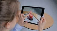 Woman Using Tablet Device With Augmented Reality App - 3D Model Of Human Heart Stock Footage