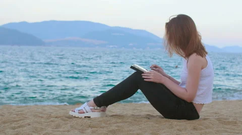 Woman using tablet device on the beach at sunset Stock Footage 62869368