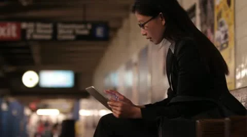 Woman Using Tablet Device on Dark Subway Platform Vídeos de archivo 20648160