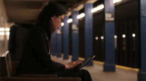 Woman Using Tablet Device as Subway Train Arrives Vídeos de archivo 20666836