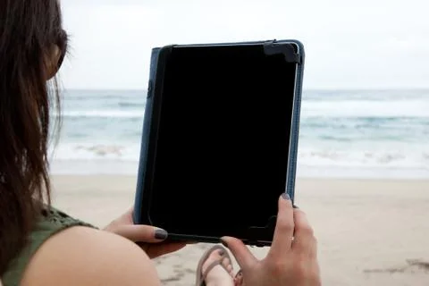 Woman using tablet device while on a beach Stock Photos