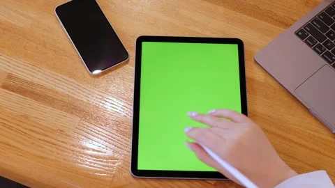 Woman is using a tablet with a green screen Stock Footage 314268184