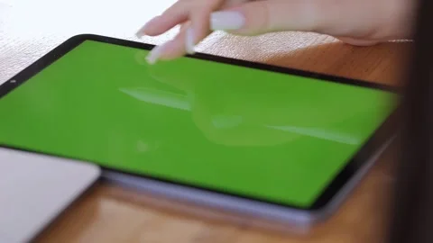 Woman is using a tablet with a green screen Stock Footage 318787146