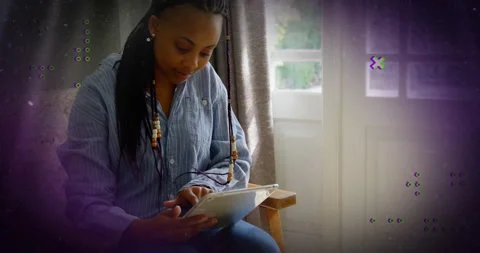 Woman using tablet in home interior, with animated data graphs illustrating Stock Footage 307444908