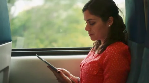 Woman using a tablet inside a moving train Stock Footage 56241865