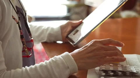 Woman using tablet to order medications online or check prescriptions Stock Footage 274676737