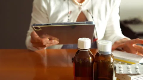 Woman using a tablet to order medications online or check prescriptions Stock Footage 274676744