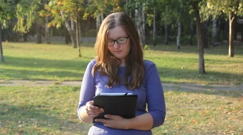 Woman using tablet in park Stock Footage 55230398