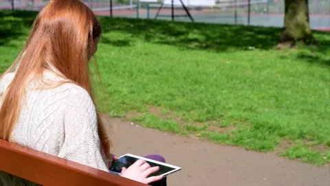 Woman Using Tablet In Park Stock Footage 90736956