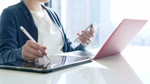 Woman using a tablet pc and a smart phone in office. Slow motion. Stock Footage 149719302