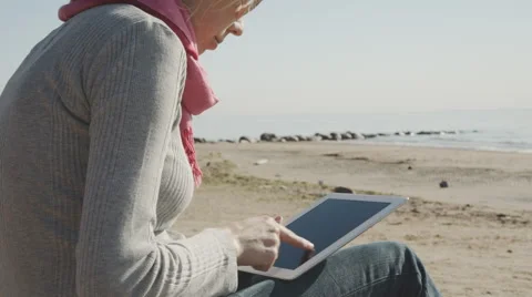 Woman using  tablet pc on the beach Stock Footage 54635025
