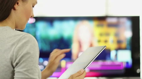 Woman using tablet pc in front of tv HD Stock Footage 40510461