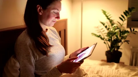 Woman using tablet pc at home at night Stock Footage 148107780