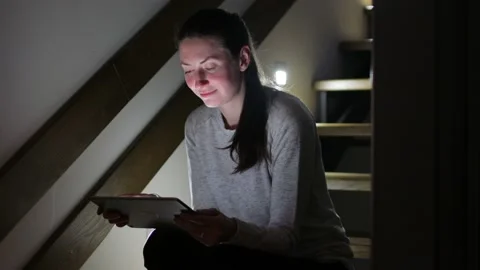 Woman using tablet pc at home at night Stock Footage 148108947
