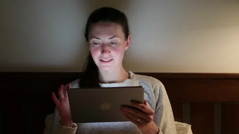 Woman using tablet pc at home at night Stock Footage 148109415