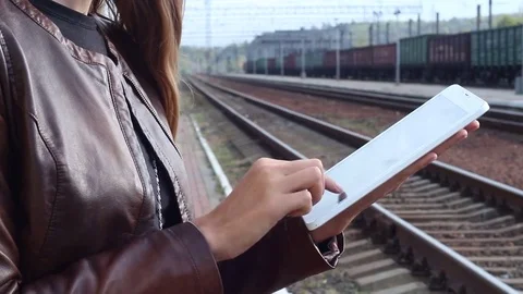Woman using a tablet on a railway platform Stock Footage 77076202