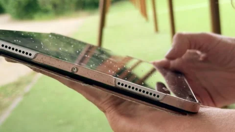 Woman Using a Tablet with Raindrops on the Screen Outdoors Stock Footage 340990770